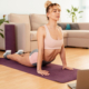 Kobieta ćwiczy na macie w domu.
